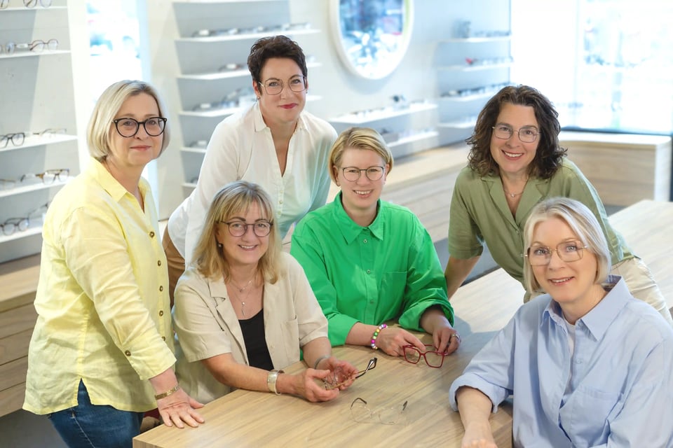 Gruppe von Frauen mit Brillen an einem Besprechungstisch