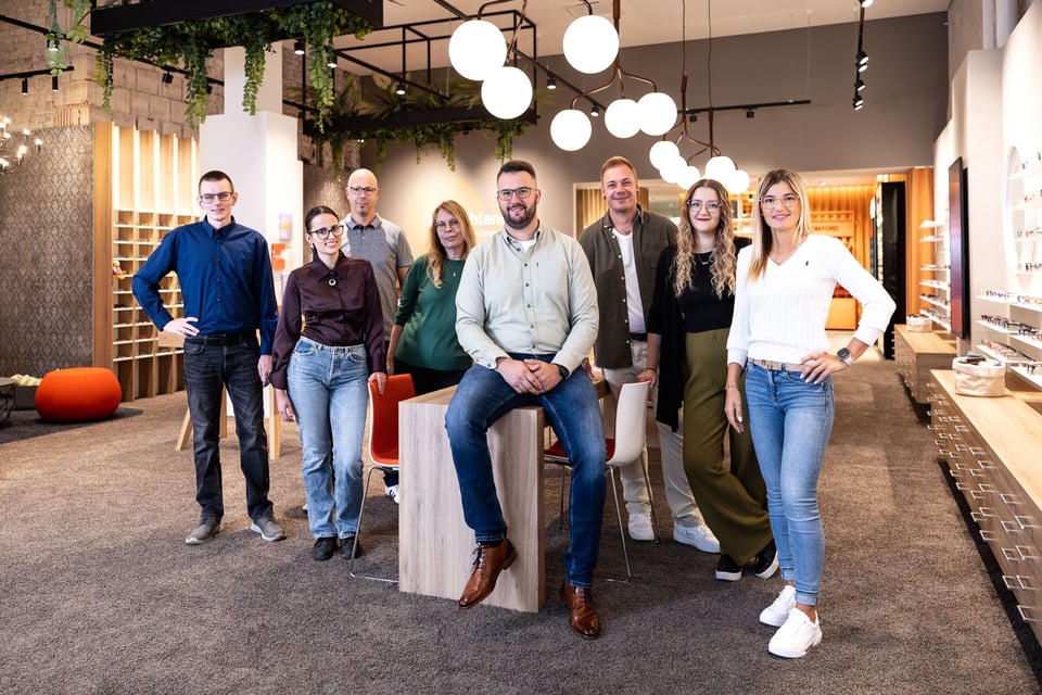 Das Team von Neusehland posiert in einer Filiale für die Kamera