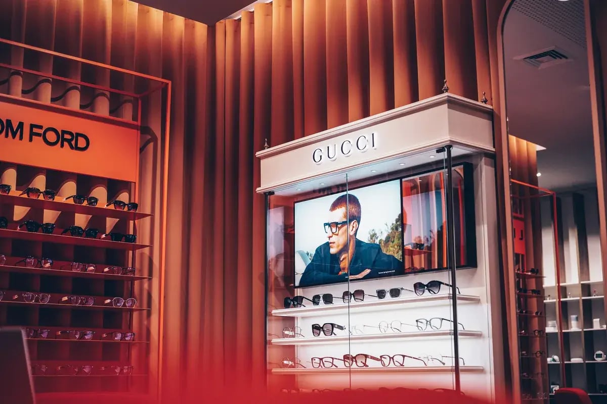 Brillendisplay mit Markenbrillen von Gucci und Tom Ford in einem Optikergeschäft