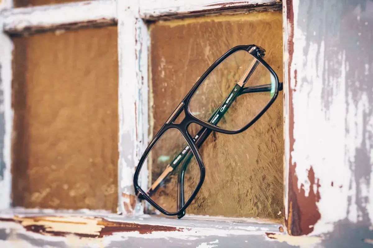 Brille liegt in einer Fensterlaibung, Nahaufnahme im Gegenlicht.