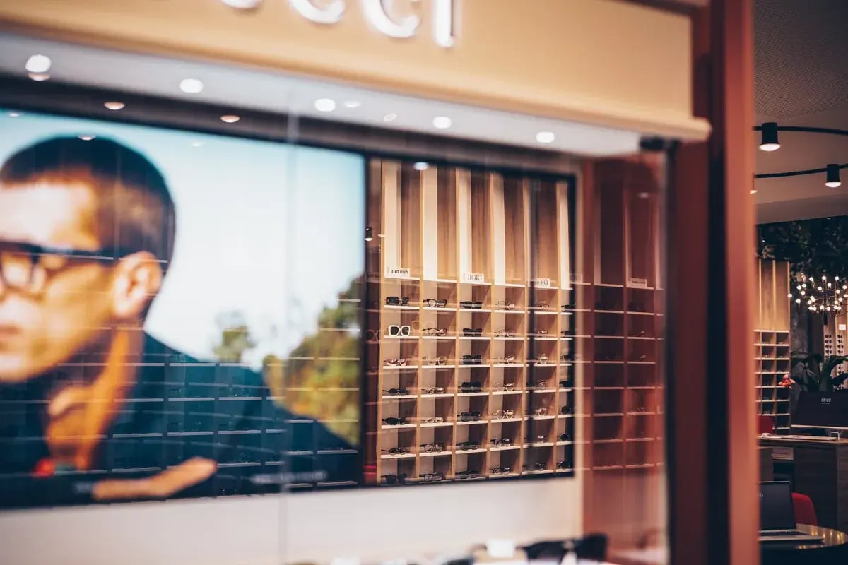 Brillengeschäft-Schaufenster mit Wandvitrine voller Brillen und Logo "Gucci"