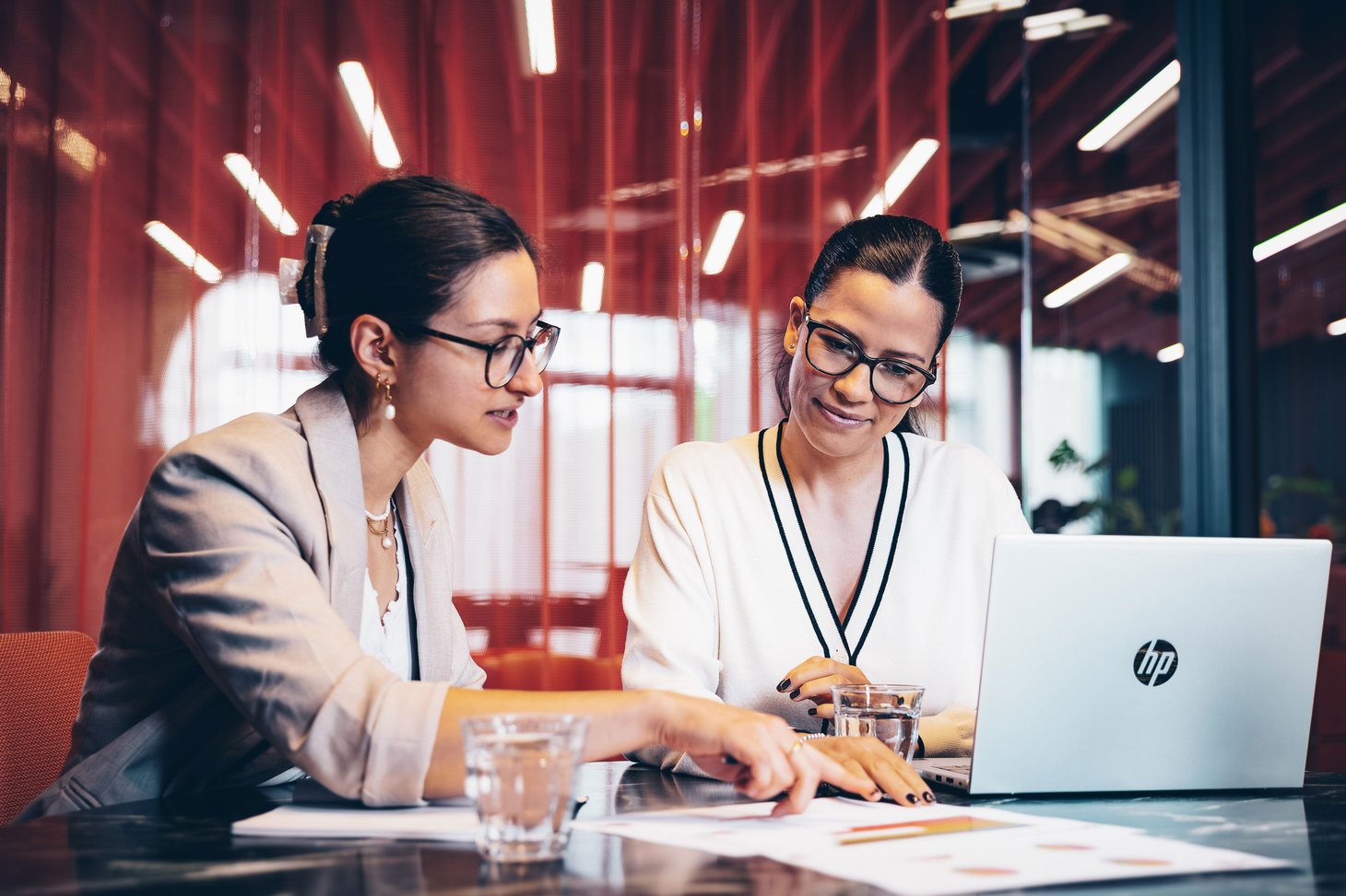 Frauen mit Arbeitsplatzbrille besprechen Ihre Unterlagen
