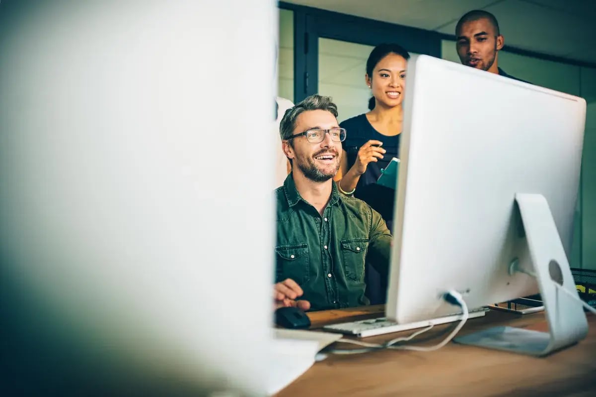 Mann mit Brille sitzt an einem Computerarbeitsplatz im Büro