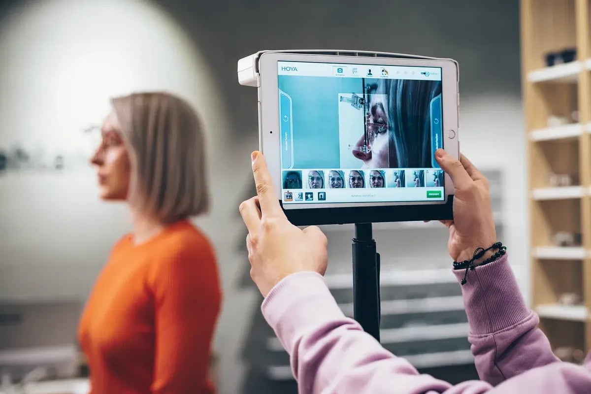 Optikerin vermisst Brillengläser mit einem Tablet und Hoya-Software