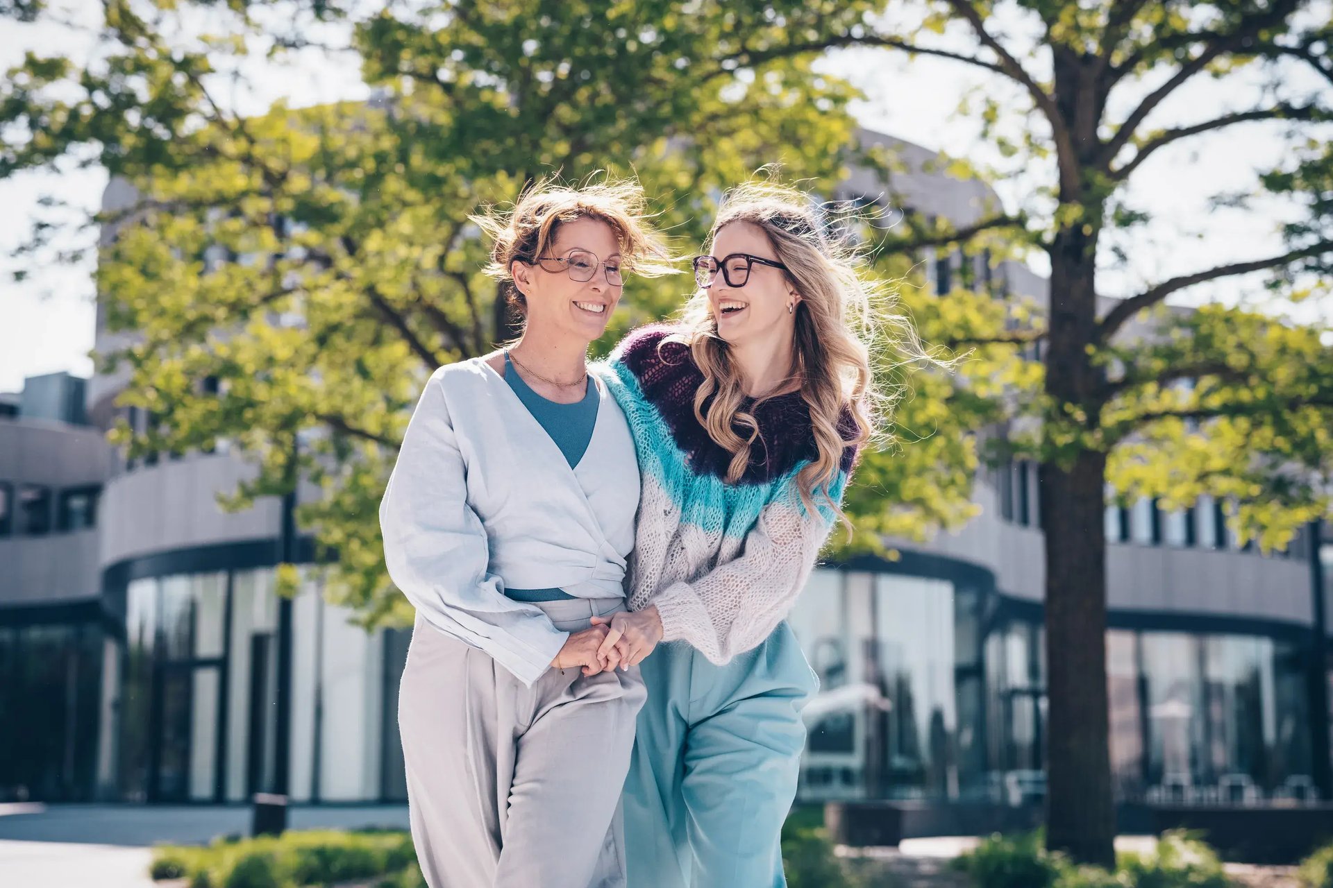 Zwei Frauen mit Brillen stehen im Freien und unterhalten sich