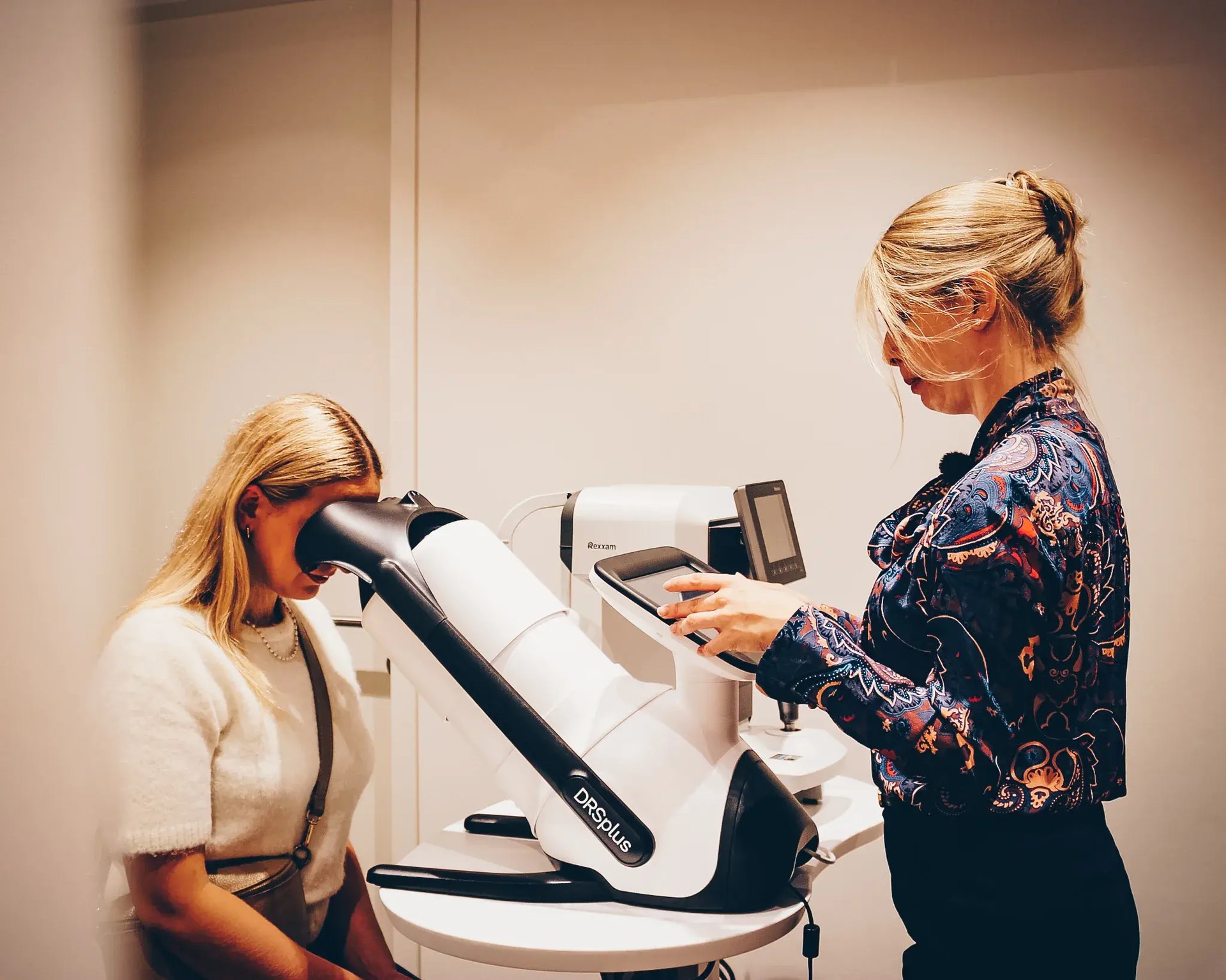Optikerin führt einen Augenscan mit dem DRS+ Gerät an einer Patientin durch