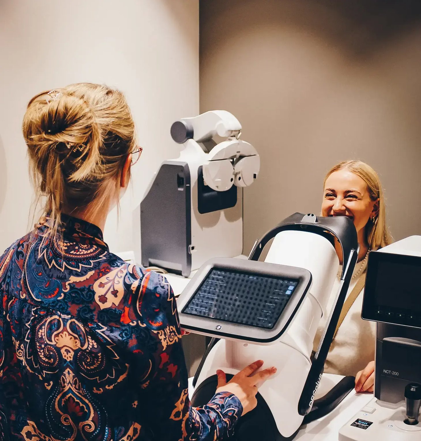 Optikerin führt einen Augenscan mit dem DRS+ Gerät an einer Patientin durch