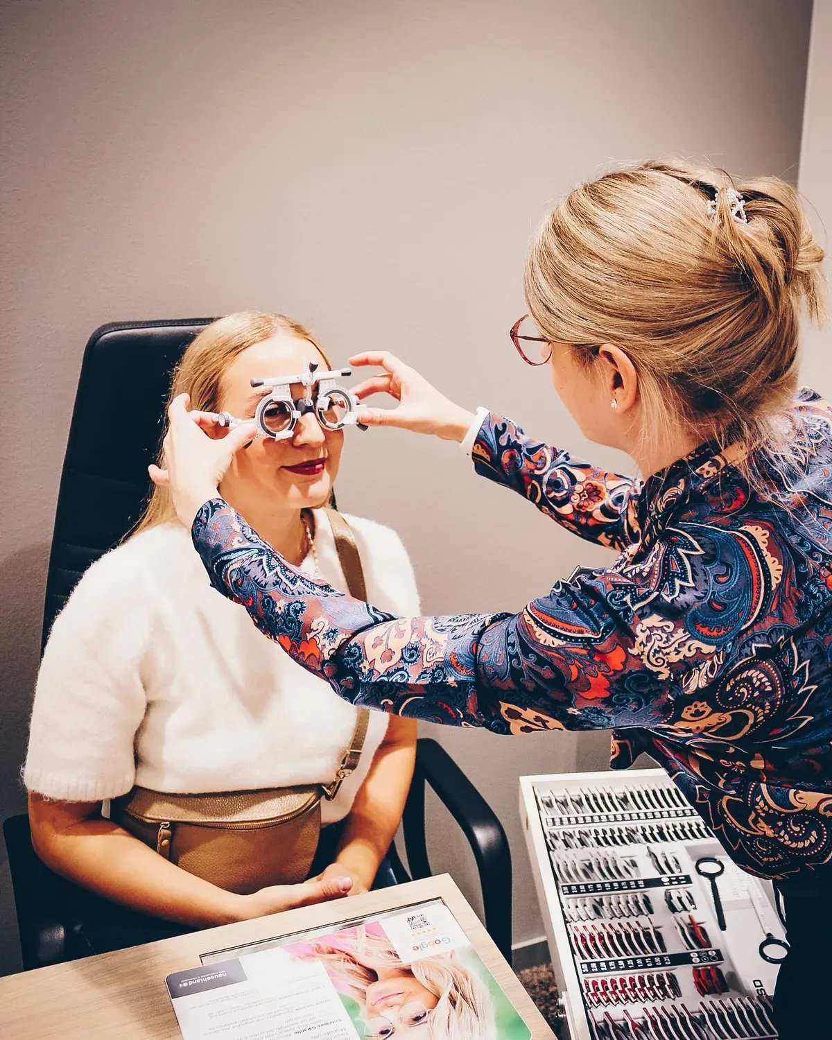 Optikerin hält eine Probierfassung für einen Sehtest bereit