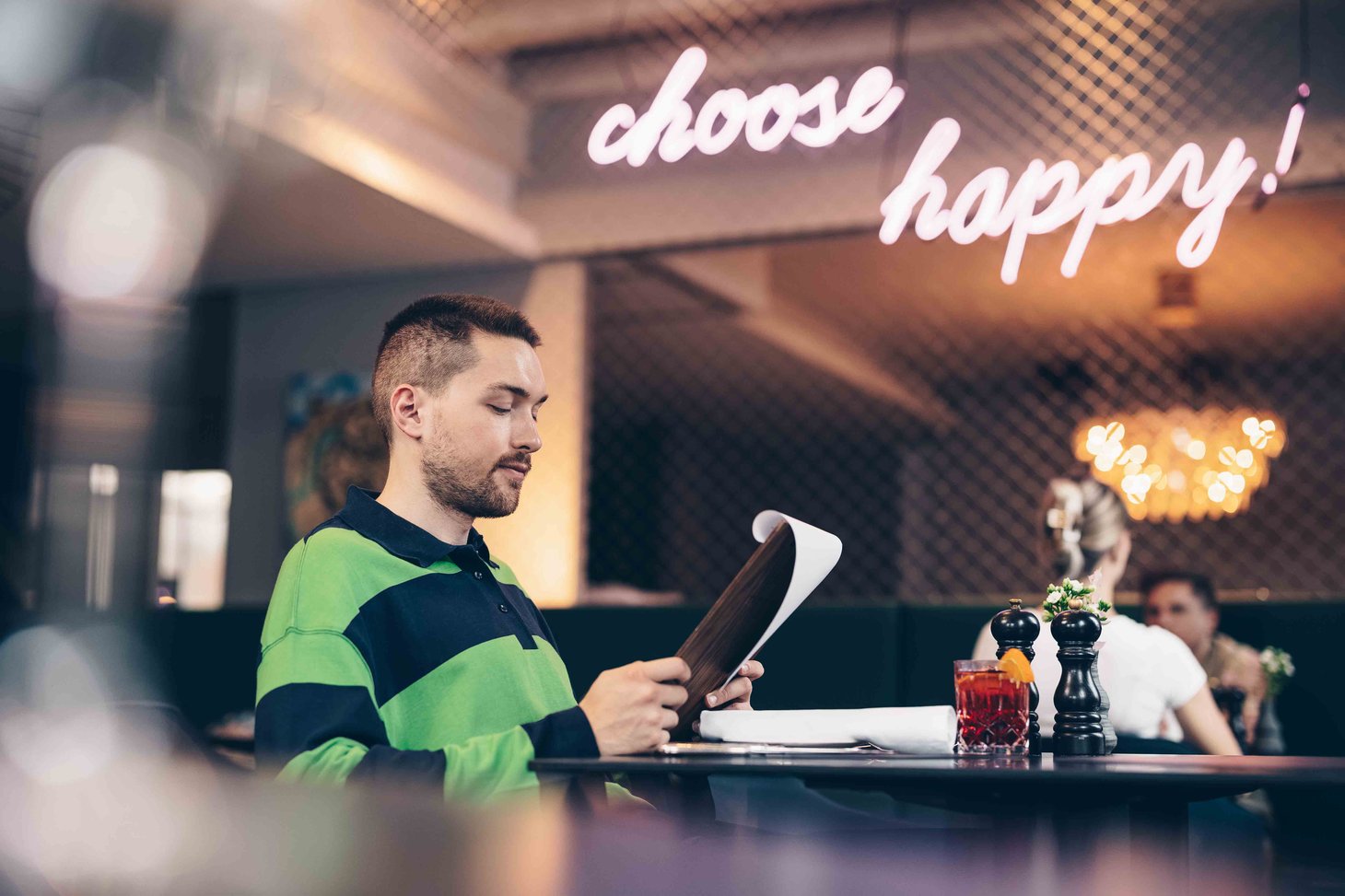 Ein Mann sitzt im Restaurant und schaut sich die Speisekarte an.