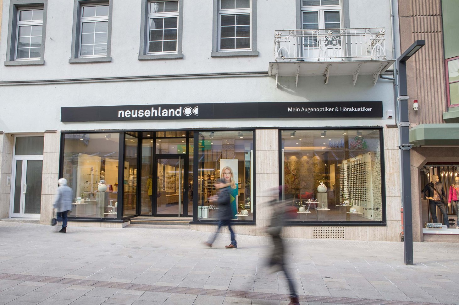 Ladenfront mit Schriftzug "neusehland – Mein Augenoptiker &amp; Hörakustiker" in Fußgängerzone