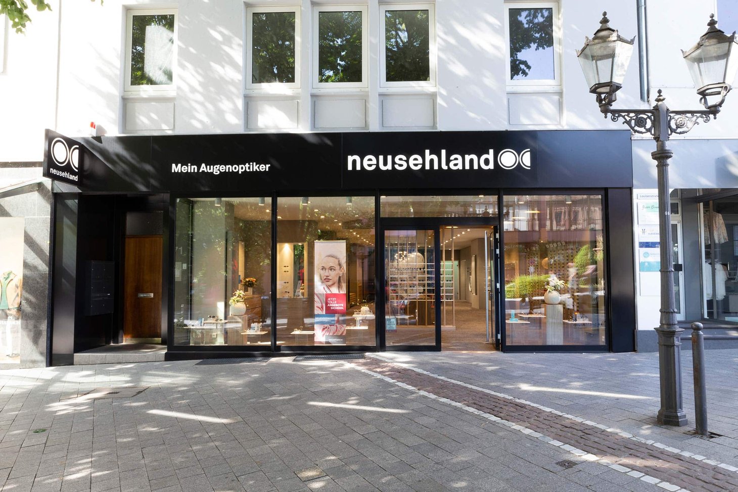 Außenansicht der neusehland-Filiale mit Schriftzug "Mein Augenoptiker" an schwarzer Fassade