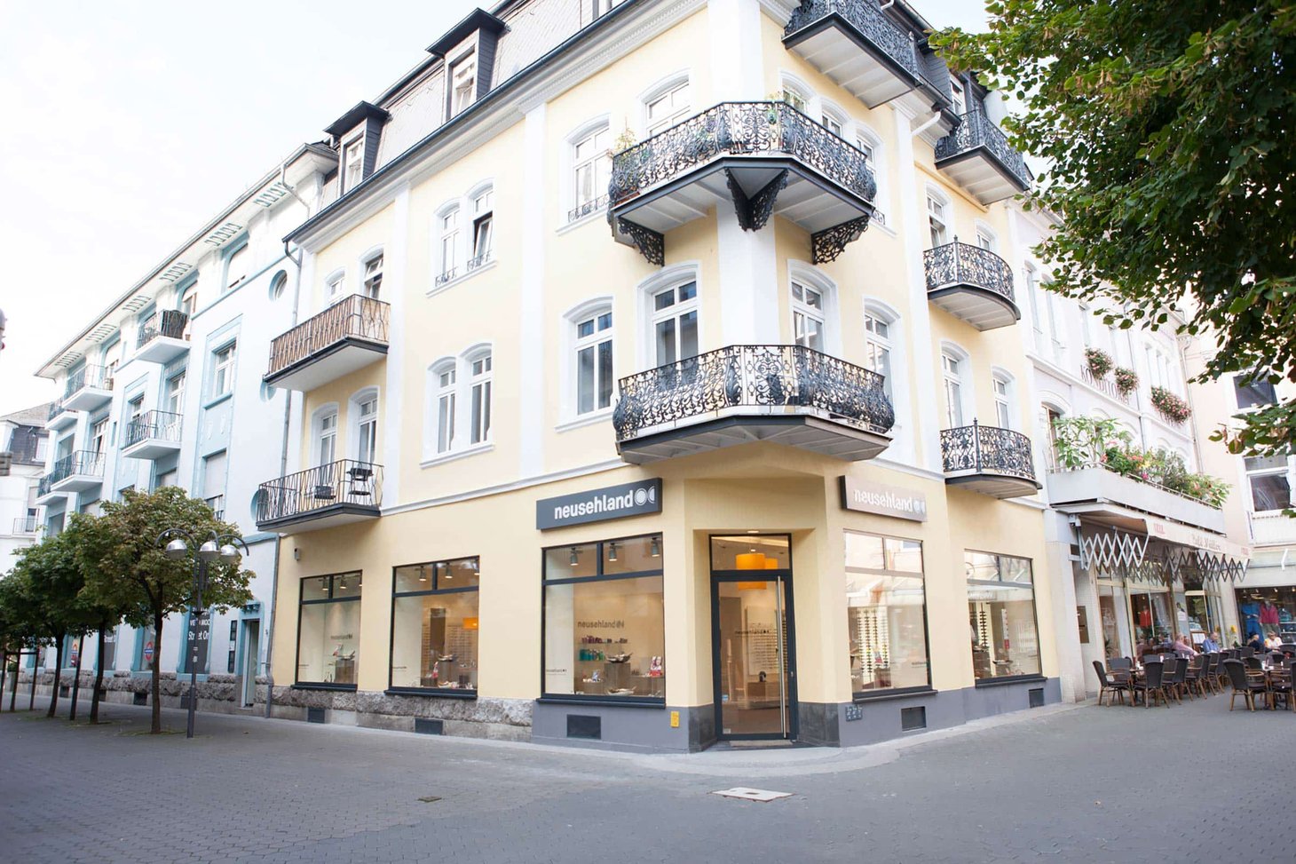 Außenansicht der neusehland-Filiale in einem Jugendstil-Eckgebäude mit Balkonen