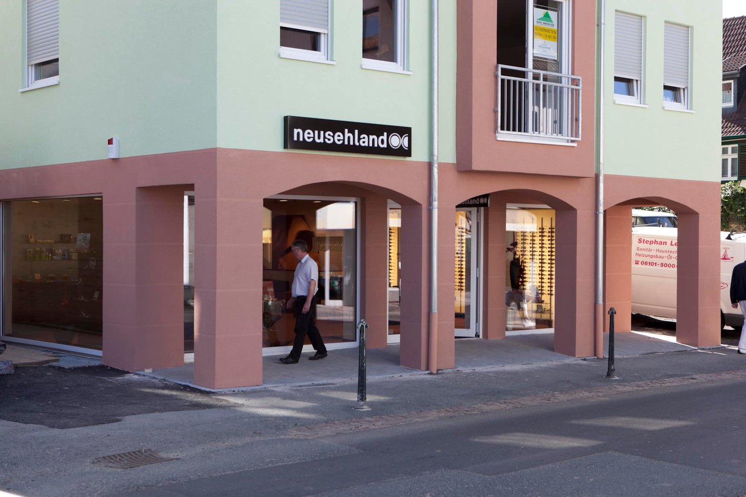 Eckgebäude mit Fachwerk und zwei Ladeneingängen mit Schriftzug "neusehland"
