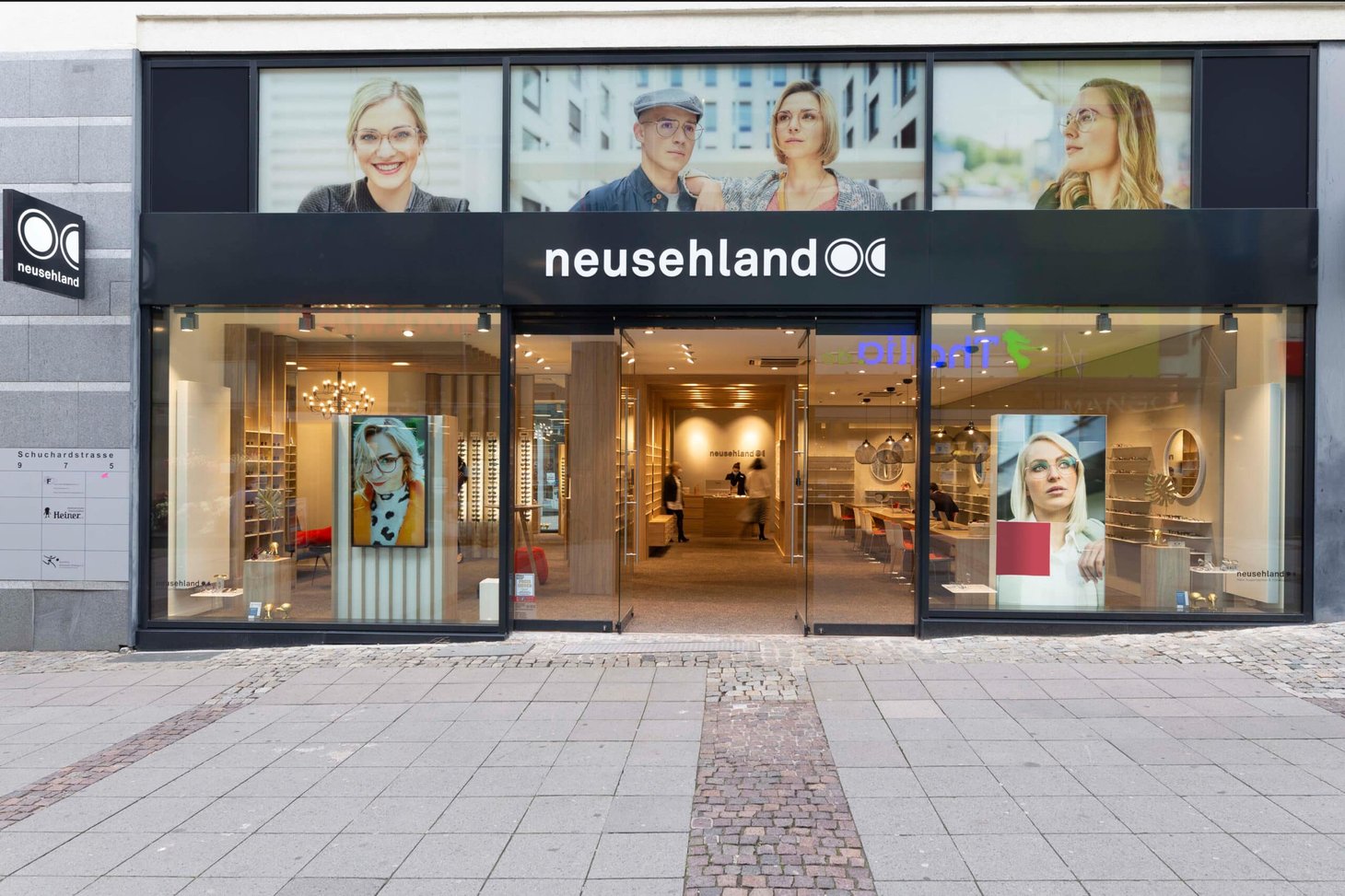 Ladenfront mit Schriftzug "neusehland" und großen Portraitfotos im Schaufenster