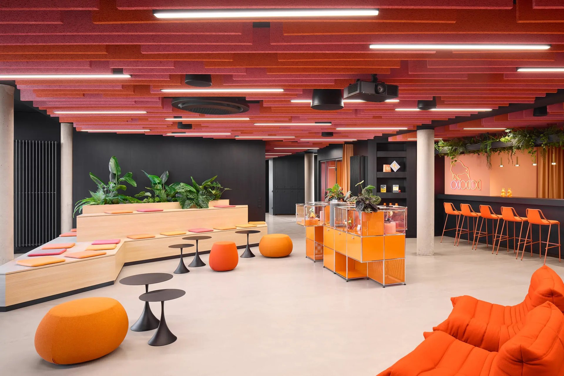 Lounge-Bereich mit orangefarbenen Polstermöbeln und moderner Einrichtung.